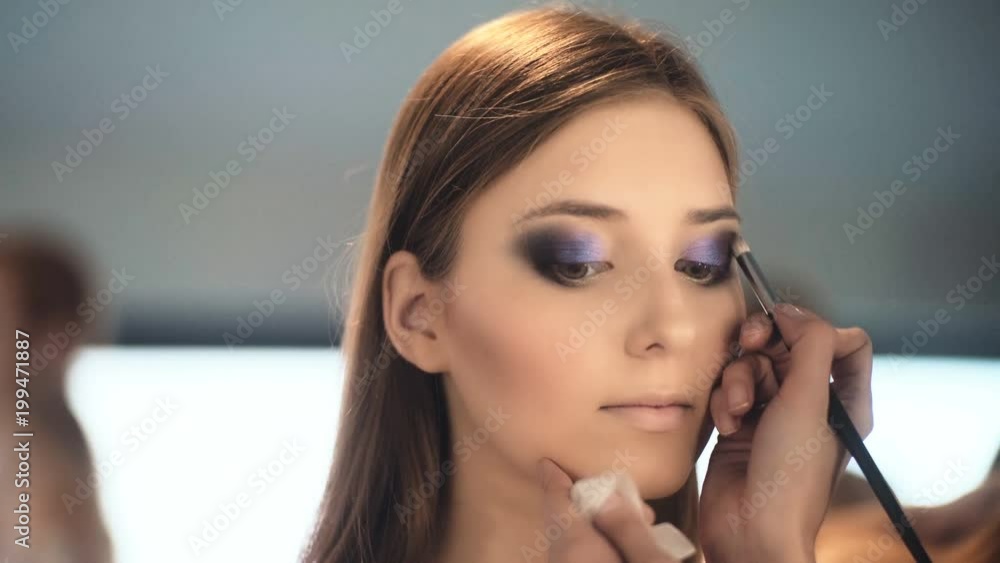 Makeup artist apply makeup to an attractive young woman. Makeup for young girl. Young girl in beauty salon. Makeup artist apply makeup to an attractive young woman. Makeup for young girl. Young girl in beauty salon.