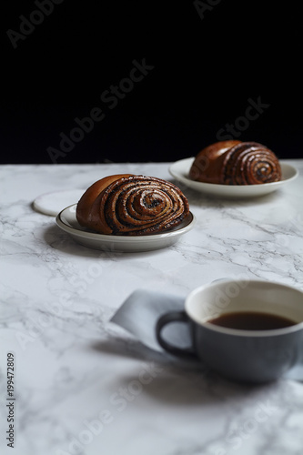 Breakfast with sweet rolls with poppy seeds on marble table photo