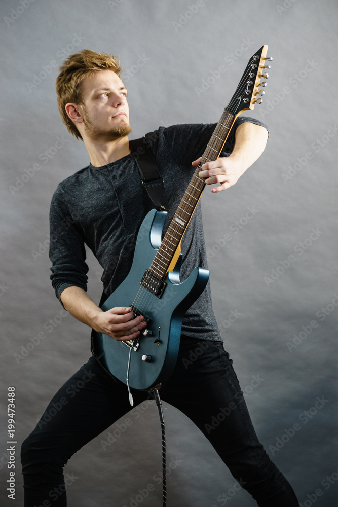 Obraz premium Young man playing electric guitar