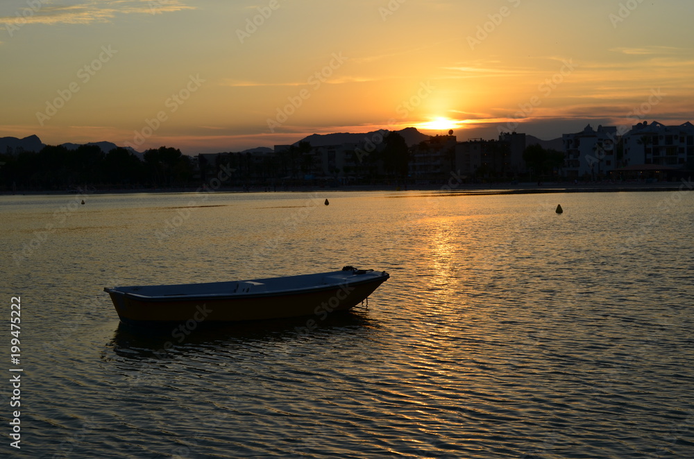 Zachód słońca nad wodą, łódka na pierwszym planie