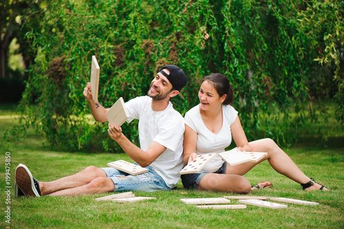 Young man and woman playing giant dominoes in the Park on the grass.