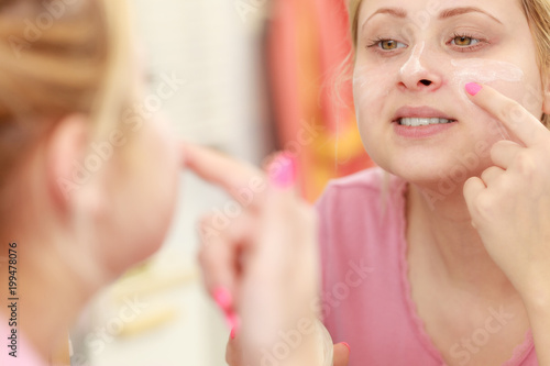 Woman applying face cream with her finger