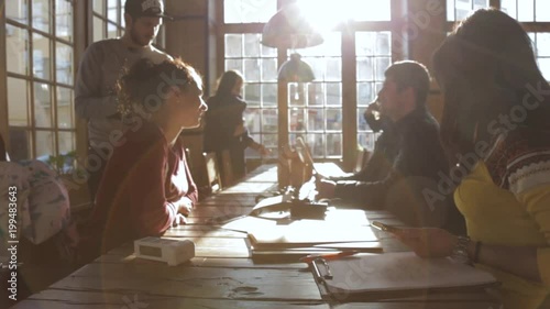 Group of young mixed race people talking and smiling in cafe