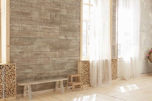 Large windows with wooden frames in a light beige wooden living room