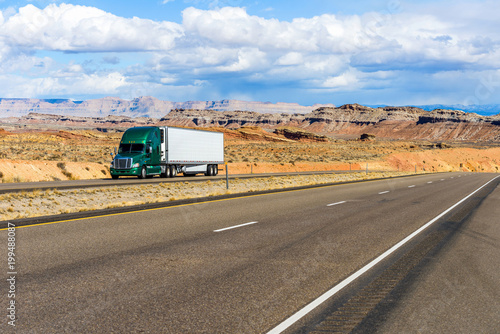 Desert Highway - A semi-trailer truck driving on Interstate Highway I-70 in colorful desert land, Utah, USA.