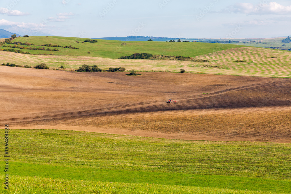 Summer hills landscape with tractor in Slovakia.