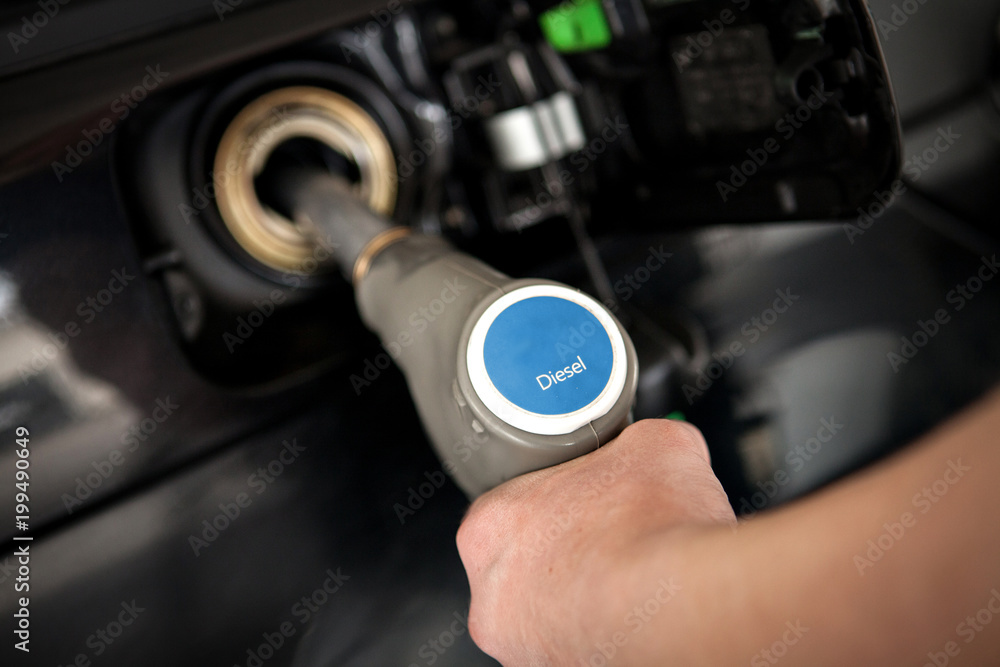 Hand filling tank with diesel at a self service gas station Hand filling tank with diesel at a self service gas station