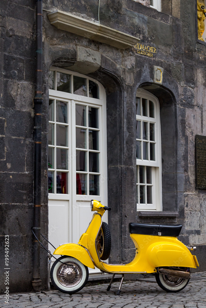 Naklejka premium A yellow retro style scooter parked in Essen
