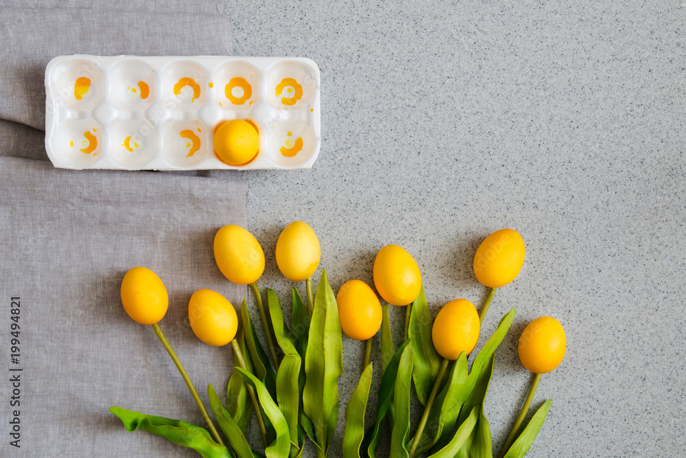 Obraz premium Easter eggs in the form of a bouquet of tulips on the table top made of artificial acrylic stone. The creative concept of the celebration of Easter, an unusual approach to decorating