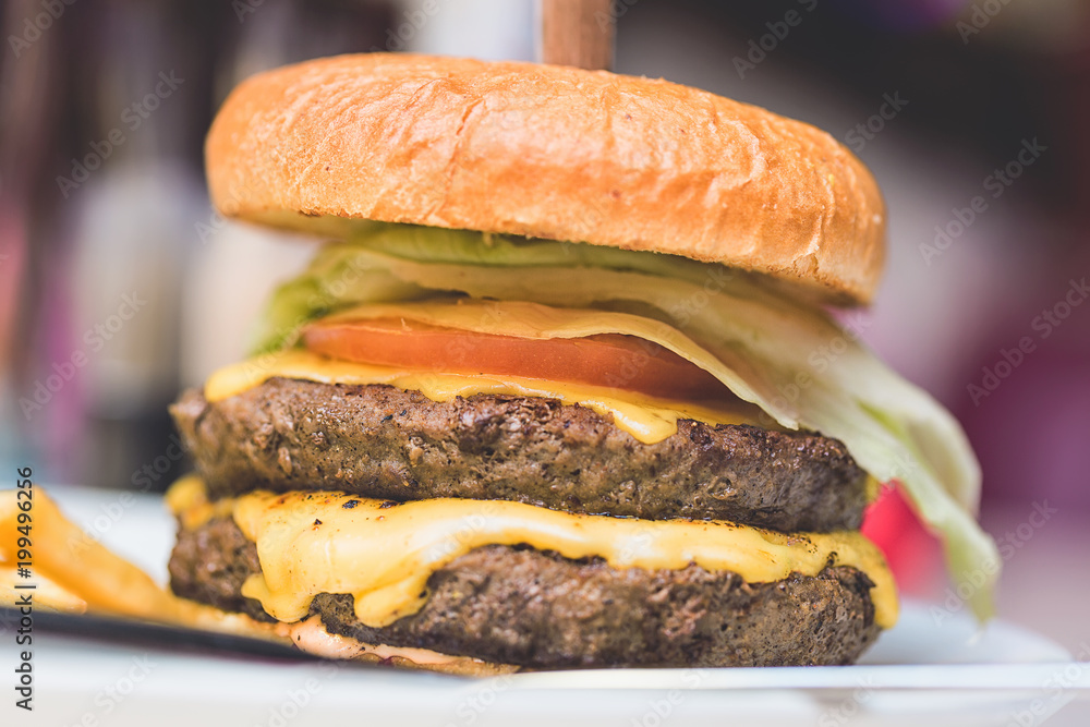 Fast food concept. Big fresh tasty meat burger. Close up image with selective focus Fast food concept. Big fresh tasty meat burger. Close up image with selective focus