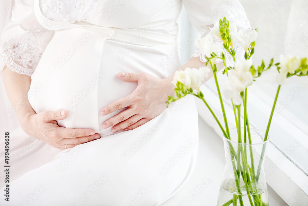 Close-up Image of pregnant woman touching her belly with hands