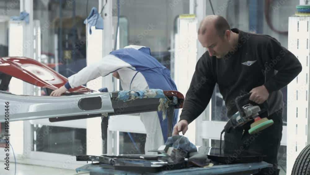 Car manufacturing plant engineers working on vehicles Car manufacturing plant engineers working on vehicles