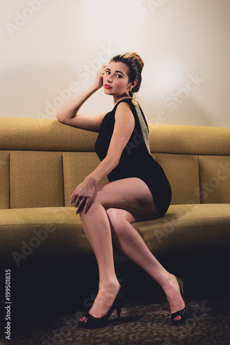 Foto Young caucasian woman dressed in mid century fasion poses in an empty bar