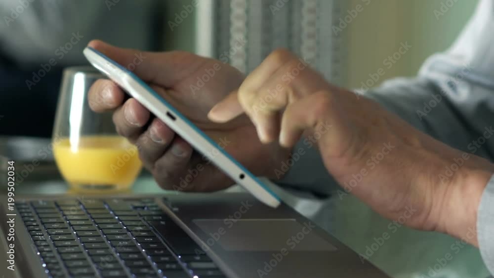 Businessman browsing Internet on tablet sitting by table at home
Businessman browsing Internet on tablet sitting by table at home