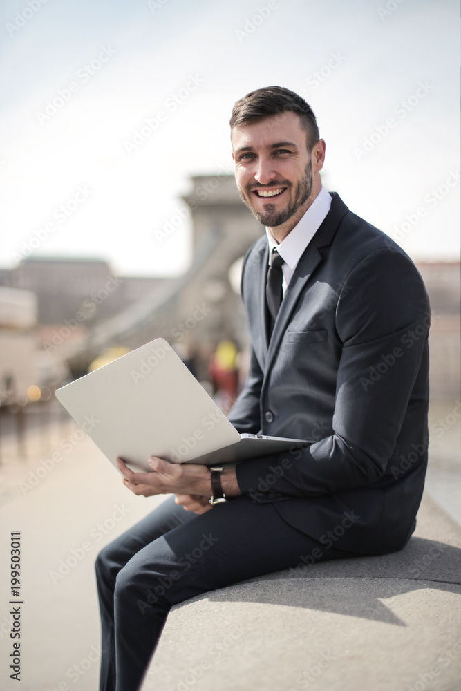Smiling businessman holding a laptop