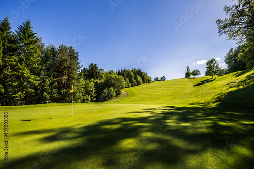 Golfplatz mit Schatten vom Baum