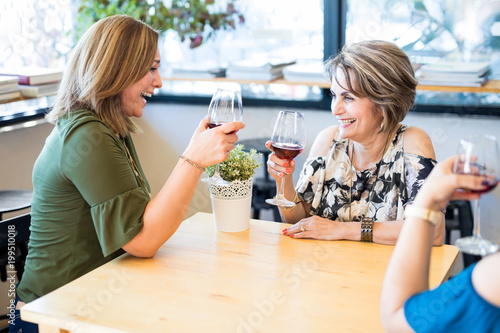 Cheerful women enjoying at cafe with a glass of wine