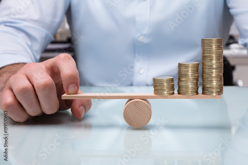 Businessperson Balancing Increasing Stacked Coins With Finger