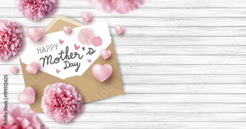 Happy mother's day on white paper in brown envelope and pink heart and carnation flowers on wood texture background with copy space