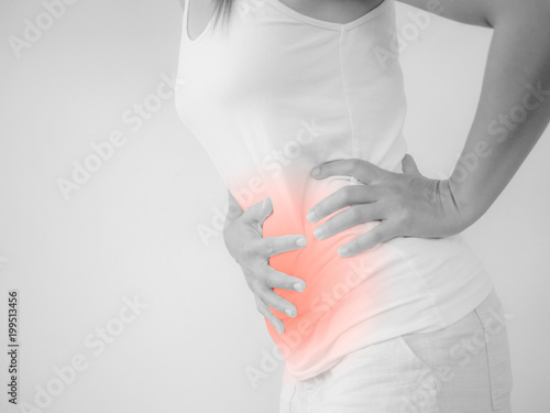 Woman having a stomachache, or menstruation pain with white background. Health care and medical concept. photo