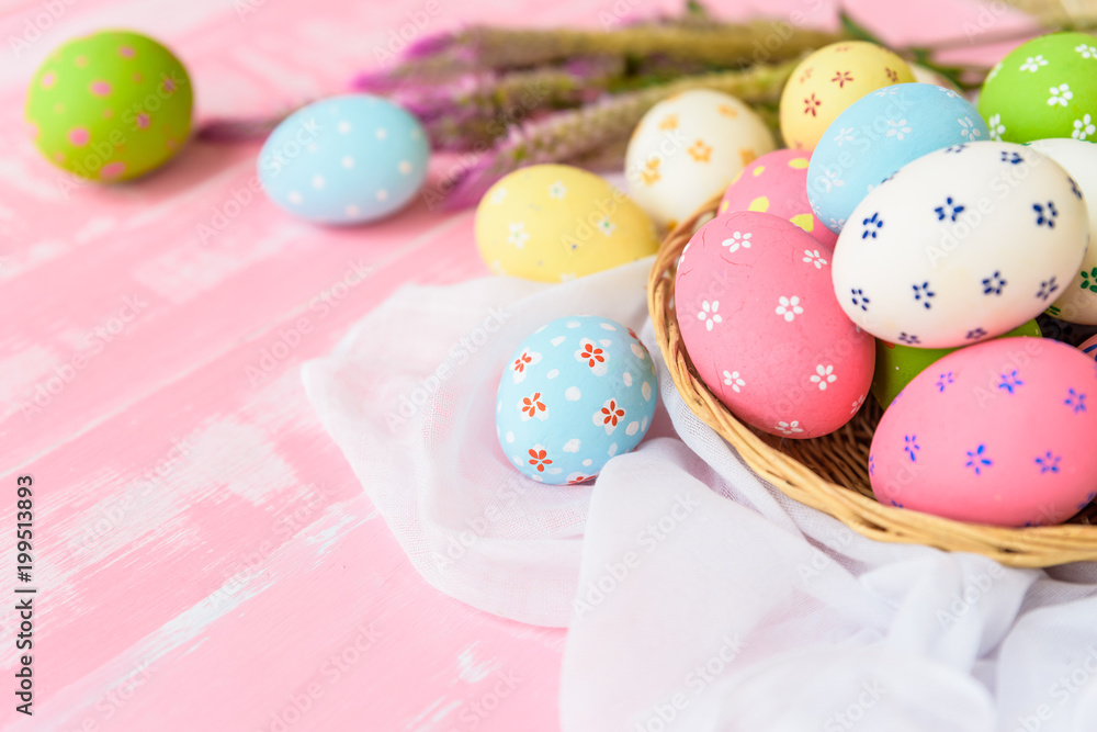 Obraz premium Happy easter! Colorful of Easter eggs in nest with paper star, flower and Feather on pastel color bright pink and white wooden background.