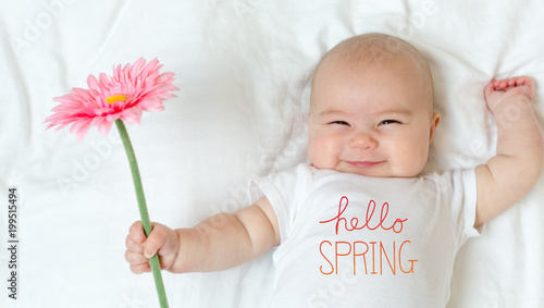 Hello Spring message with baby girl holding a flower