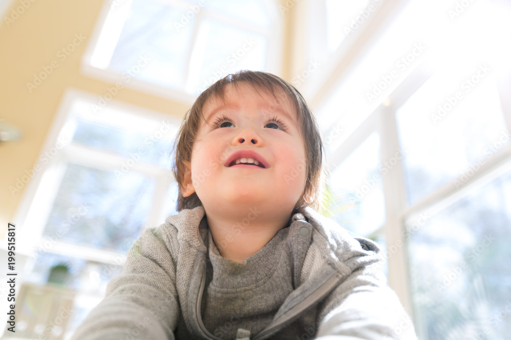 Happy toddler boy smiling in a big bright room