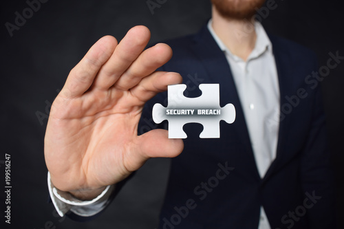 Businessman holding a puzzle with the inscription:SECURITY BREACH