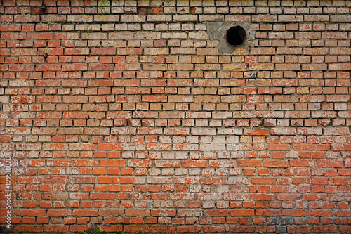 brick wall in which a pipe is visible