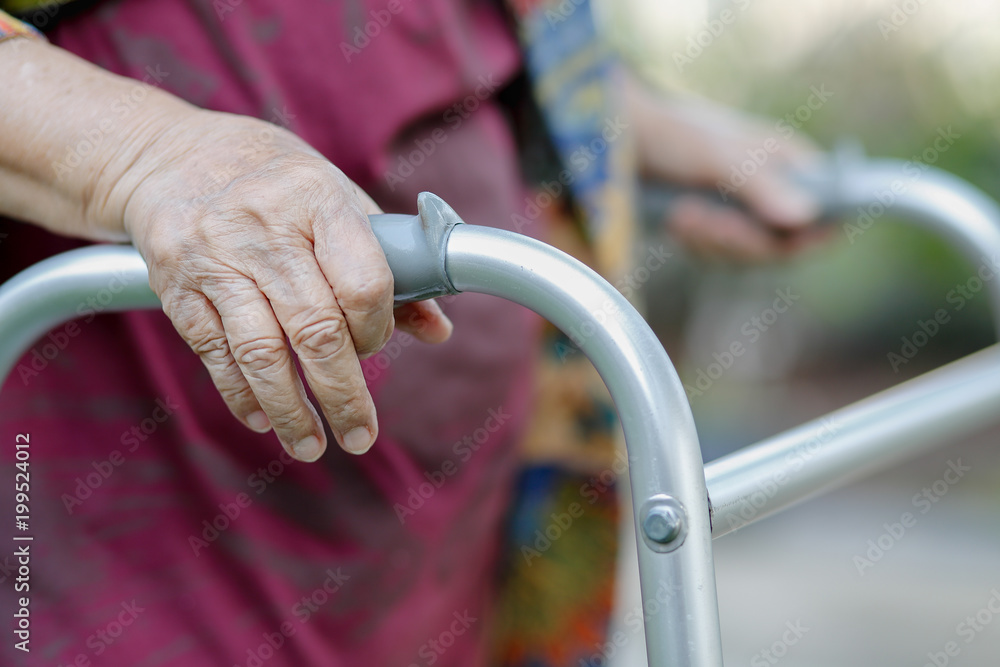 Elderly woman using a walker in backyard