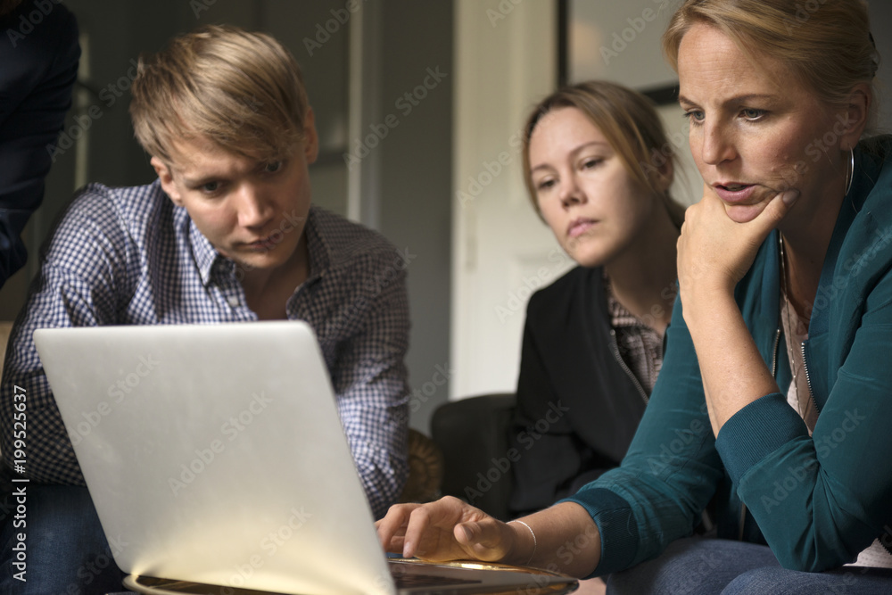 Three people having conversation over laptop Three people having conversation over laptop