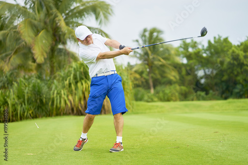 Asian man playing golf swing club for tee-off in course