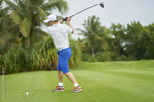 Asian man playing golf swing club for tee-off in course