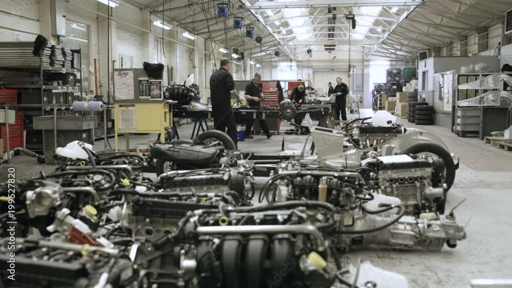 Automobile sports car manufacturing plant engineers working on vehicles Automobile sports car manufacturing plant engineers working on vehicles
