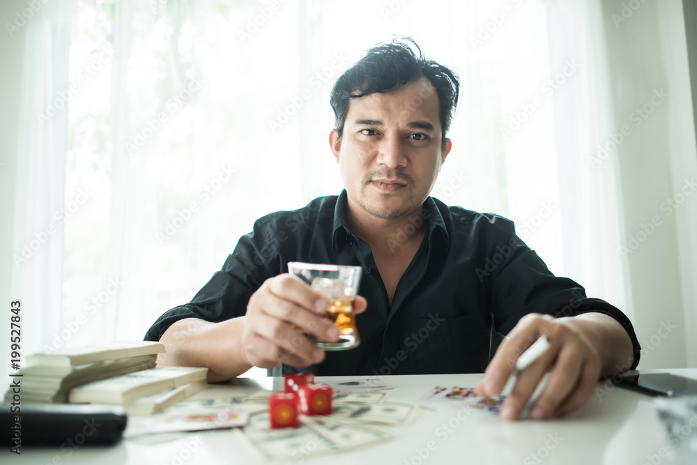 Businessman sitting in a business center bar smoking cigar and drinking whiskey Businessman sitting in a business center bar smoking cigar and drinking whiskey