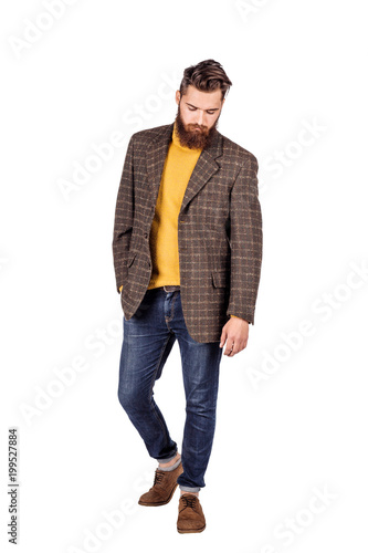 Handsome young man with beard full height standing against white background.