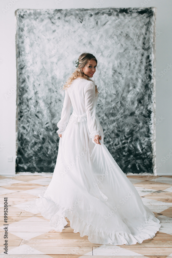 Beautiful young bride in boudoir dress on canvas background with paint. Wedding trends and ideas 2018, spring inspiration. Wedding in the Studio Beautiful young bride in boudoir dress on canvas background with paint. Wedding trends and ideas 2018, spring inspiration. Wedding in the Studio