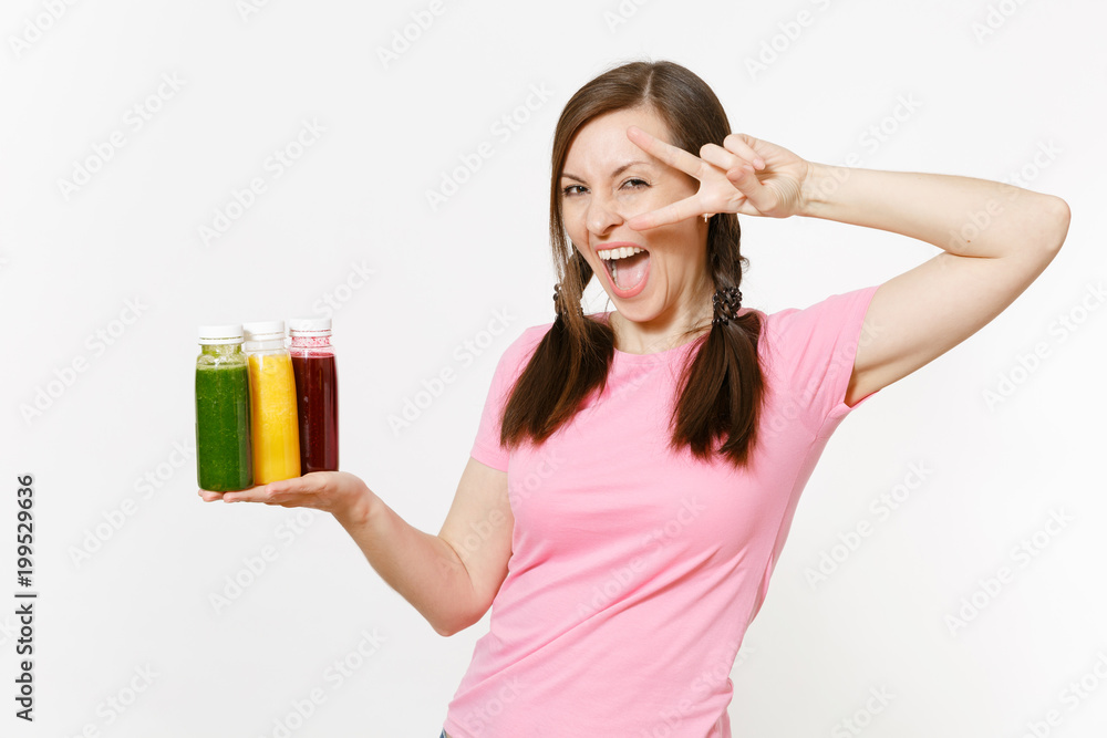 Fun woman holds row of green, red, yellow detox smoothies in bottles isolated on white background. Proper nutrition, vegetarian drink, healthy lifestyle, dieting concept. Copy space for advertisement. Fun woman holds row of green, red, yellow detox smoothies in bottles isolated on white background. Proper nutrition, vegetarian drink, healthy lifestyle, dieting concept. Copy space for advertisement.