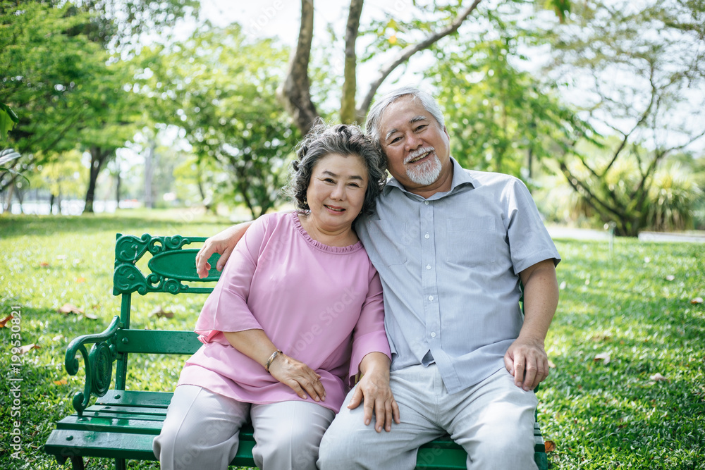 healthy senior couple relaxing seats on Chair in the park healthy senior couple relaxing seats on Chair in the park