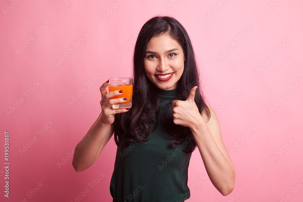 Young Asian woman thumbs up drink orange juice. Young Asian woman thumbs up drink orange juice.