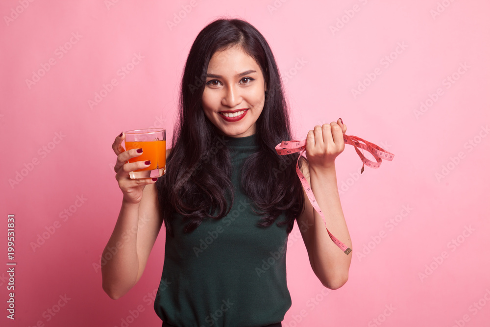 Asian woman drink orange juice hold measuring tape. Asian woman drink orange juice hold measuring tape.