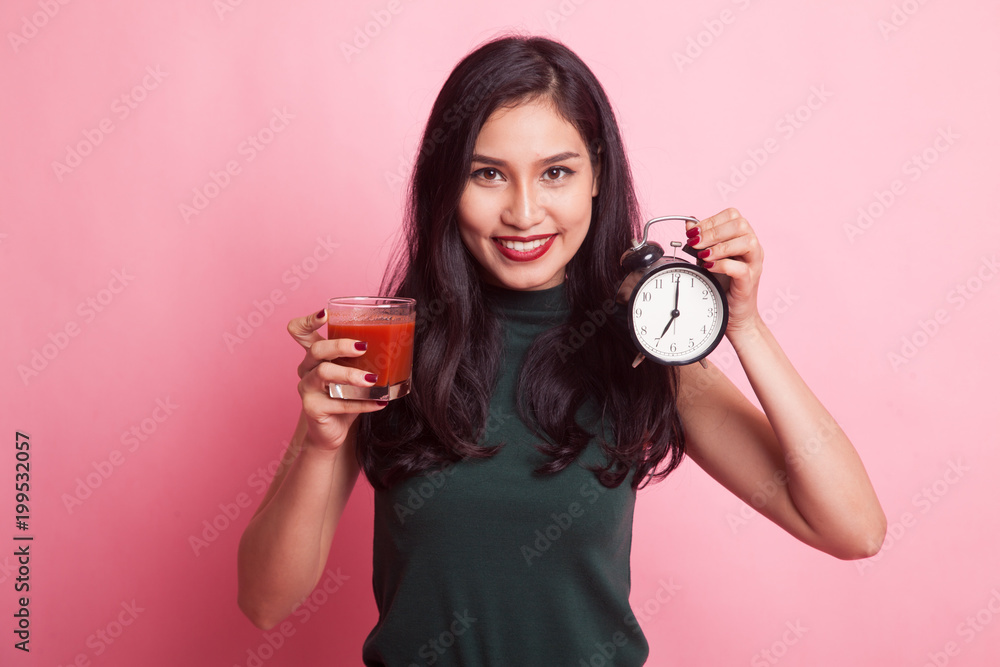 Young Asian woman with tomato juice and clock. Young Asian woman with tomato juice and clock.