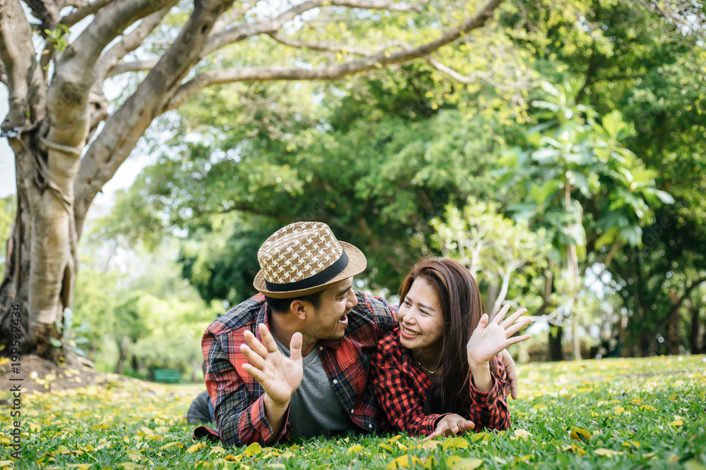 Romantic couple of young people lying on grass in park. Romantic couple of young people lying on grass in park.