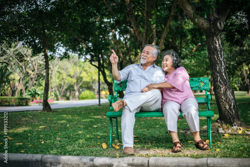 healthy senior couple relaxing  seats on Chair in the park