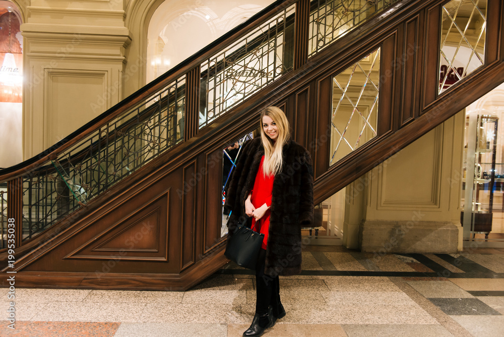 Young beautiful girl in a mink coat in gum on red square is shopping, an indoor market, Moskva Young beautiful girl in a mink coat in gum on red square is shopping, an indoor market, Moskva