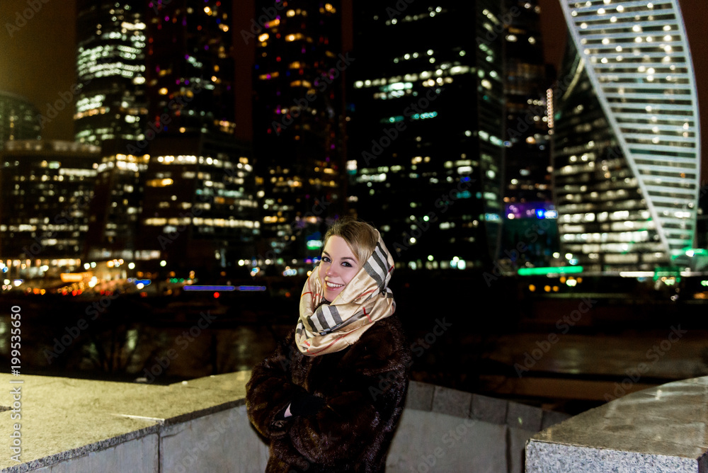 Young beautiful girl walking in night city. View of Moscow on the background. Young beautiful girl walking in night city. View of Moscow on the background.
