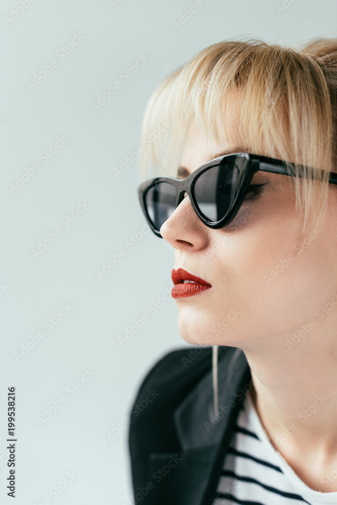 Elegant blonde girl in sunglasses with red lips isolated on grey Elegant blonde girl in sunglasses with red lips isolated on grey
