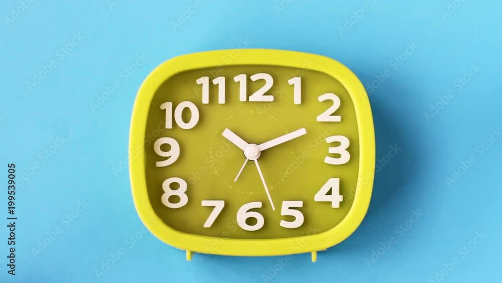 Green clock with white numbers and arrows on blue background, Time Lapse Green clock with white numbers and arrows on blue background, Time Lapse