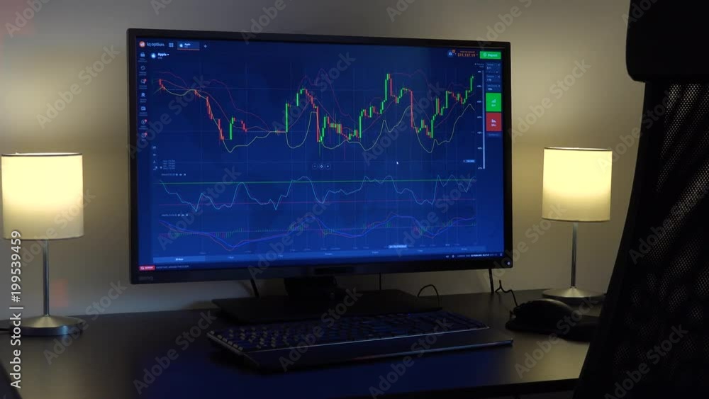 A candle chart on a computer screen in a dimly lit room A candle chart on a computer screen in a dimly lit room