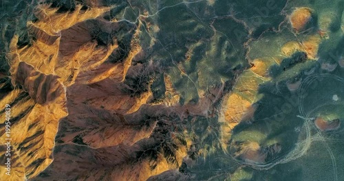 Contrast of colors and shapes. Aerial view on course, orange sandstone hills and smooth vegetation-covered lowland in Zhangye Danxia National Geopark. 